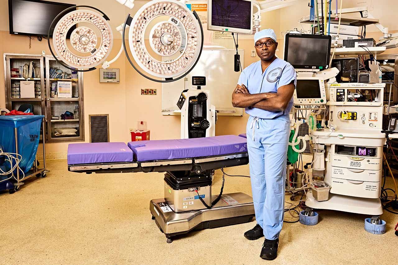 Shawn Hervey-Jumper stands with his arms crossed in an operating room.