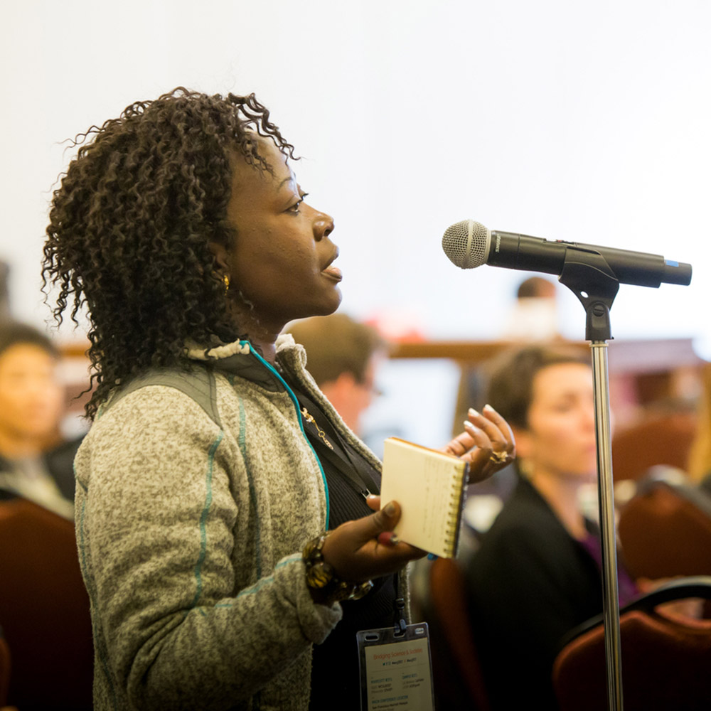 An audience member asks a question of the speakers during the WCSJ Conference