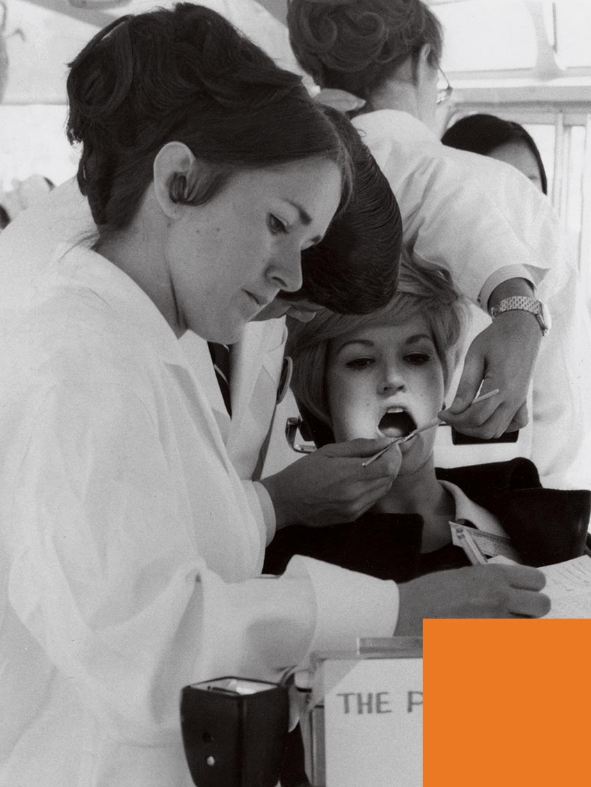 A dental student examines a patient at a mobile dental clinic in the lat 1960's.