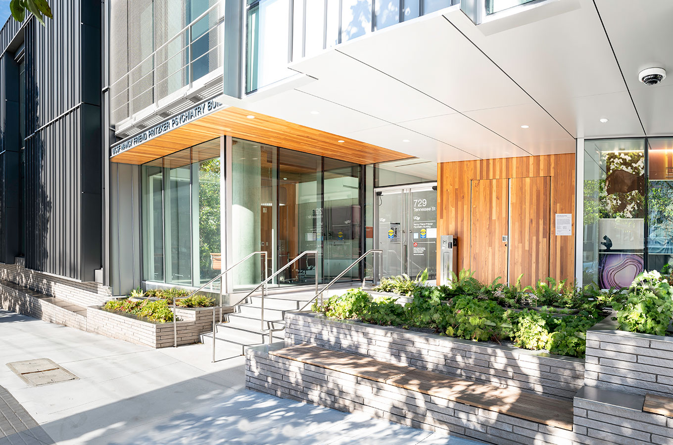 An entrance to the Nancy Pritzker building. The entrance features wood panelling and plants