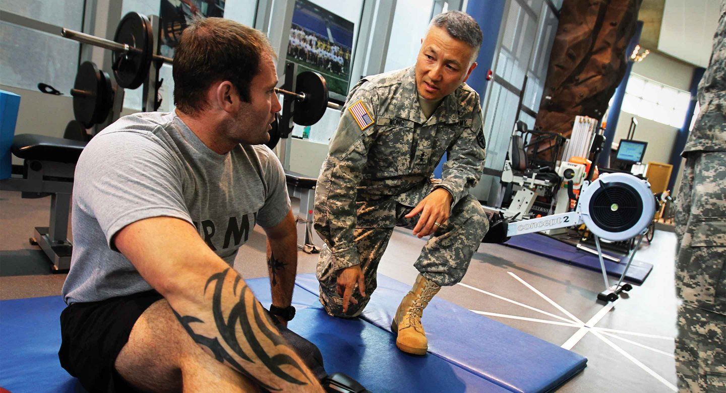 Major General Ted Wong, a School of Dentistry graduate, checks in with a patient using the Intrepid Dynamic Exoskeletal Orthosis – an indispensible rehabilitation technology developed at one of the medical centers under his command.