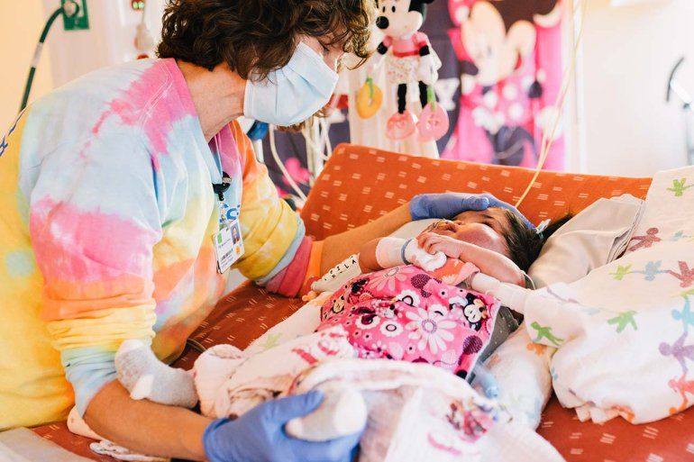 Nurse performing acupressure on an infant