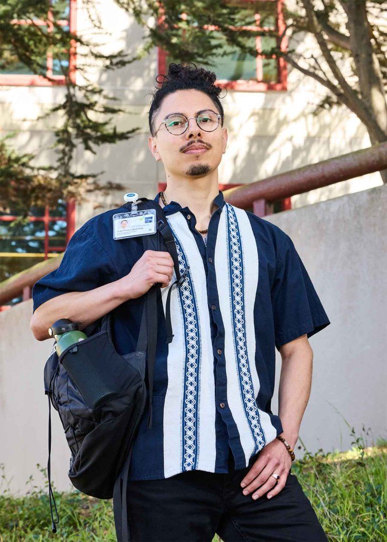 Iván Piña-Cabanillas wears a patterned shirt and holds his backpack at UCSF’s Parnassus Heights campus.