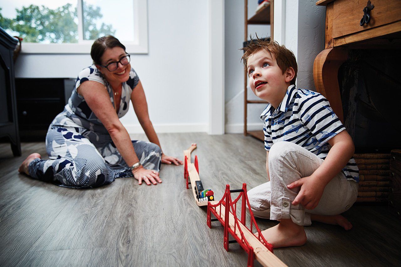 Elysa Marco plays with a train set and her son at their home