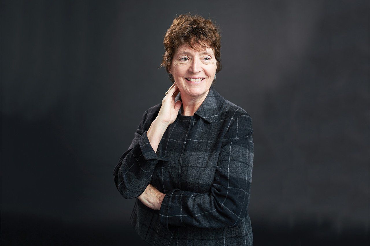 Portrait of Barbara Koenig in front of a black background.