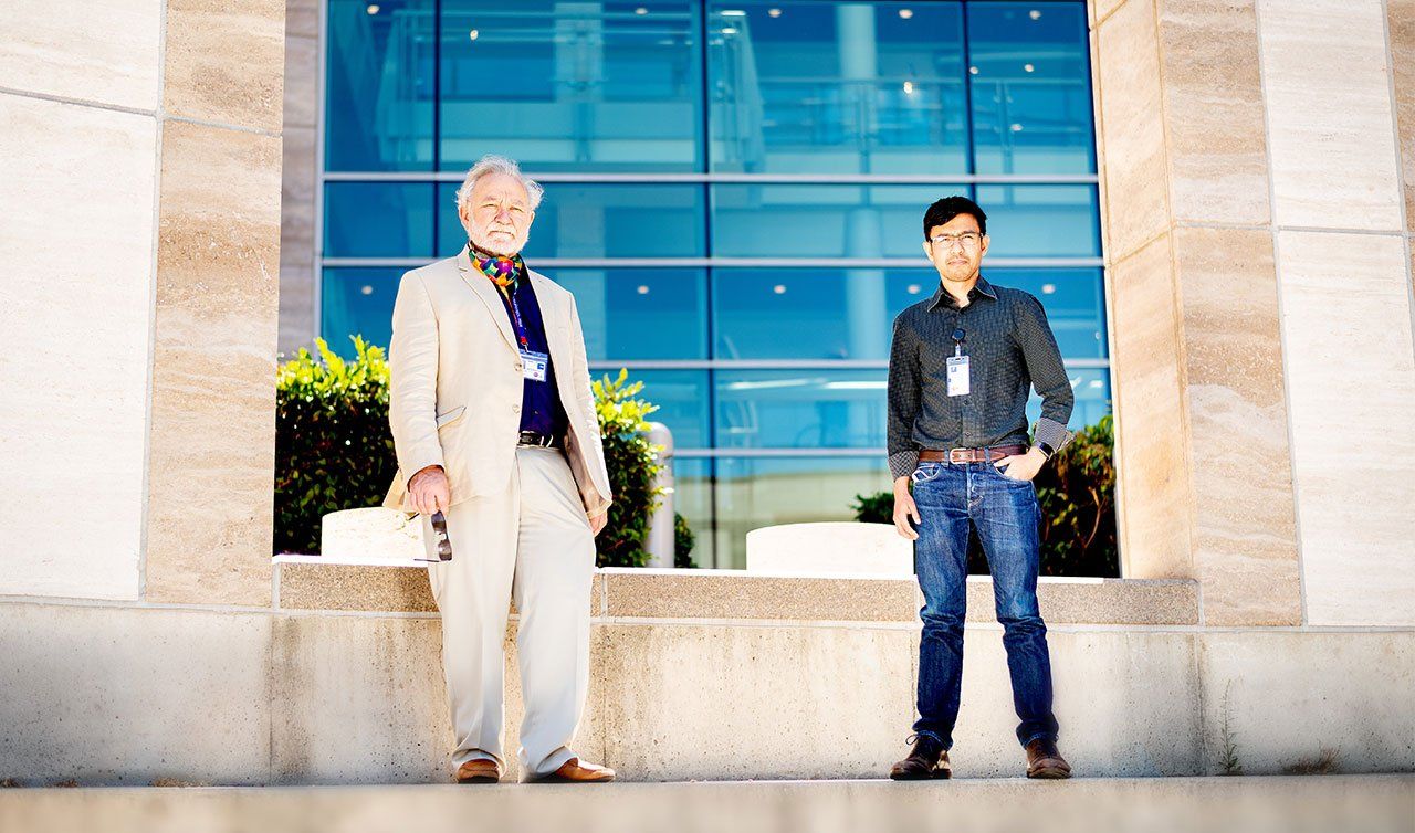 Peter Walter (left), PhD and Aashish Manglik (right), MD, PhD, stand outside Genentech Hall at UCSF’s Mission Bay Campus.