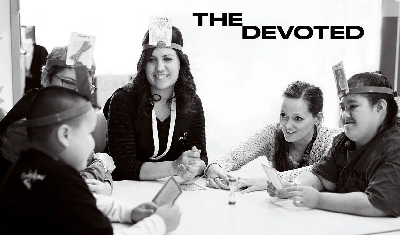 Black and white photo of Erika Shue (second from right) teaching students at the Marie Wattis School at UCSF Benioff Children’s Hospital San Francisco; text on image reads “The Devoted”