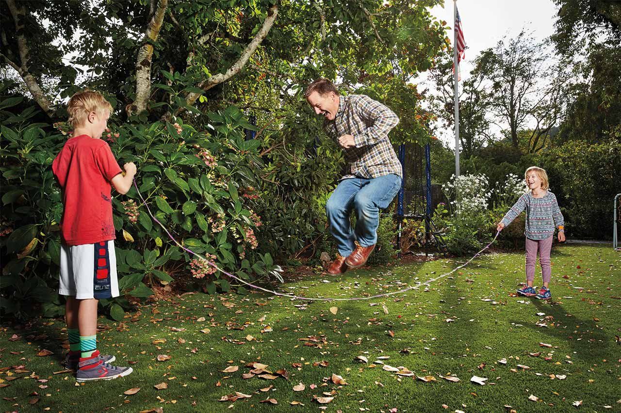Tim Wood jumps rope with two of his kids, Owen (left) and Piper (right), in their yard.