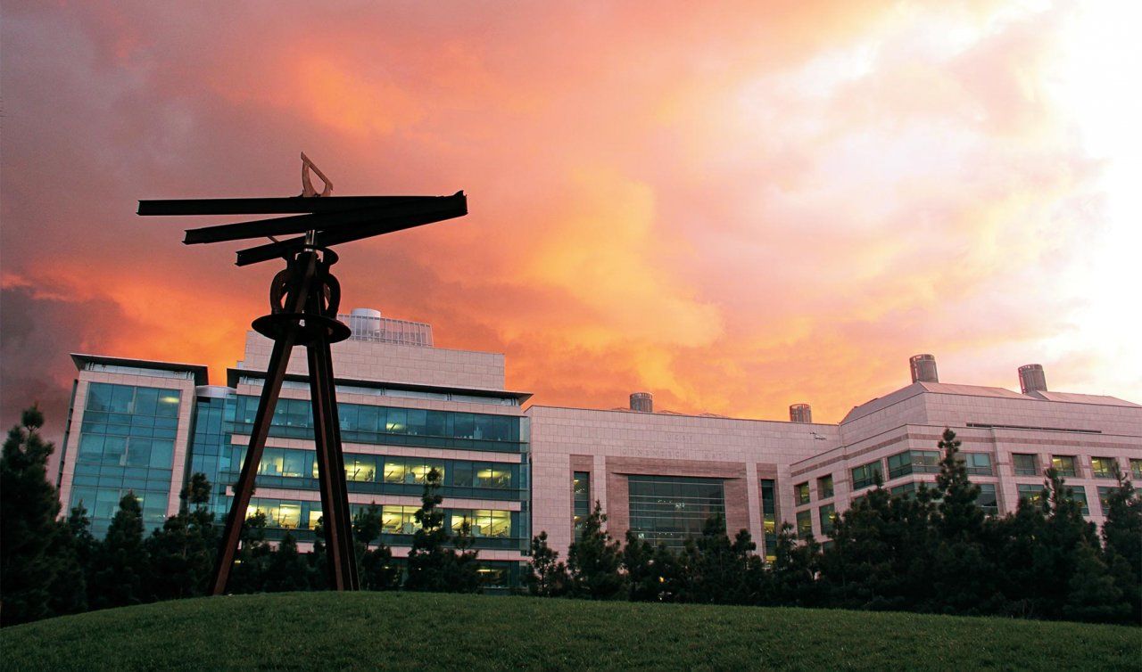 Photo of the "Dreamcatcher" large-scale, metal sculpture by artist Mark di Suvero, located in Koret Quad, UCSF Mission Bay Campus, at sunset.