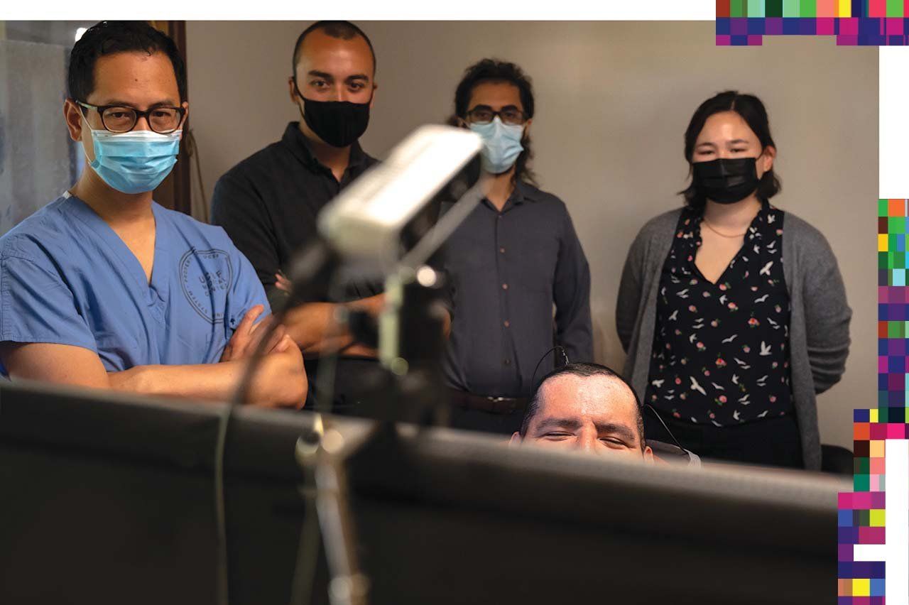 Edward Chang, his lab members, and Poncho look a screen.