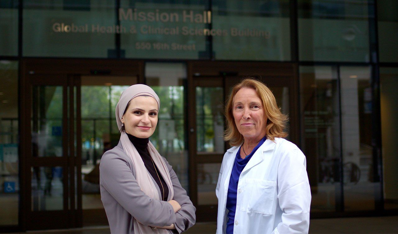 Suzanne Barakat and Coleen Kivlahan in front of the UCSF Mission Hall, Global Health and Clinical Sciences Building.