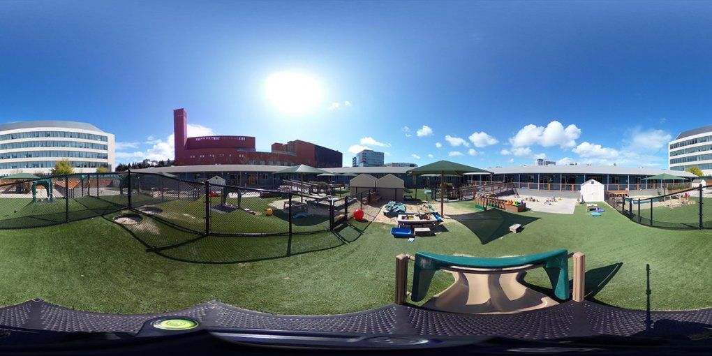 An expansive play area with umbrellas, a sandpit, climbing equipment and toys