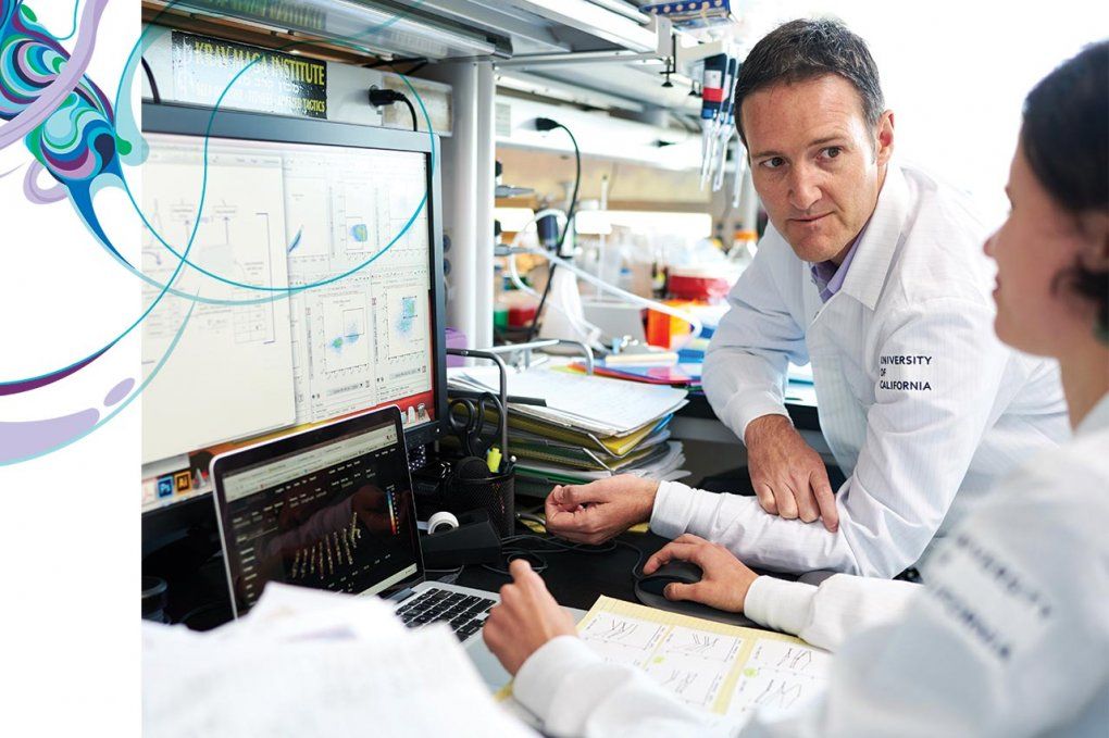 Sergio Baranzini with postdoctoral scholar Egle Cekanaviciute, look over a computer screen in the lab.