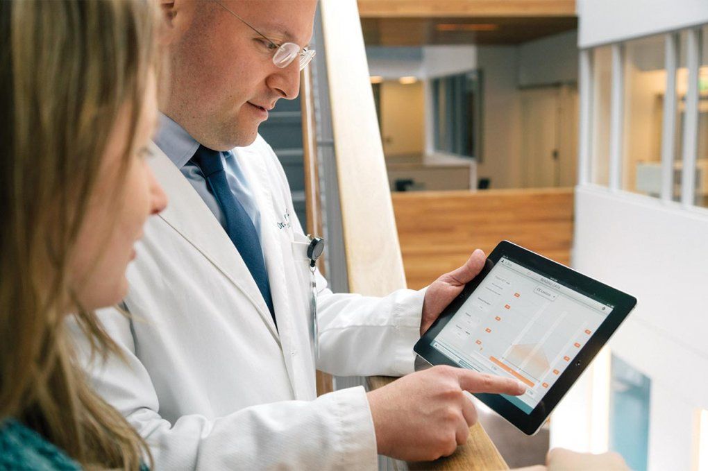 A doctor and patient look at the Bioscreen app on an iPad.
