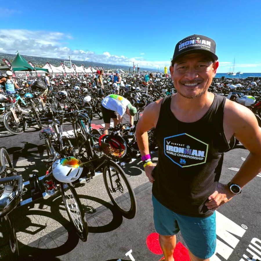 Jonathan Pascual stands in front of rows of bikes at the 2024 VinFast IRONMAN World Championship.