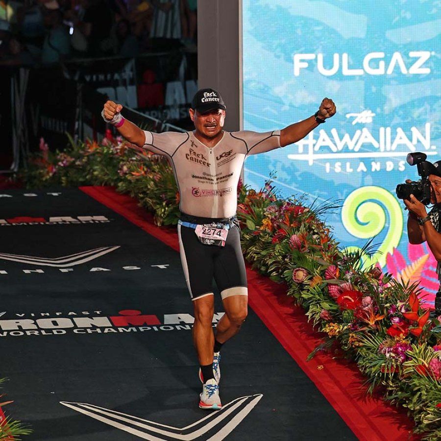 Jonathan Pascual runs with his arms held up triumphantly at the finish line.