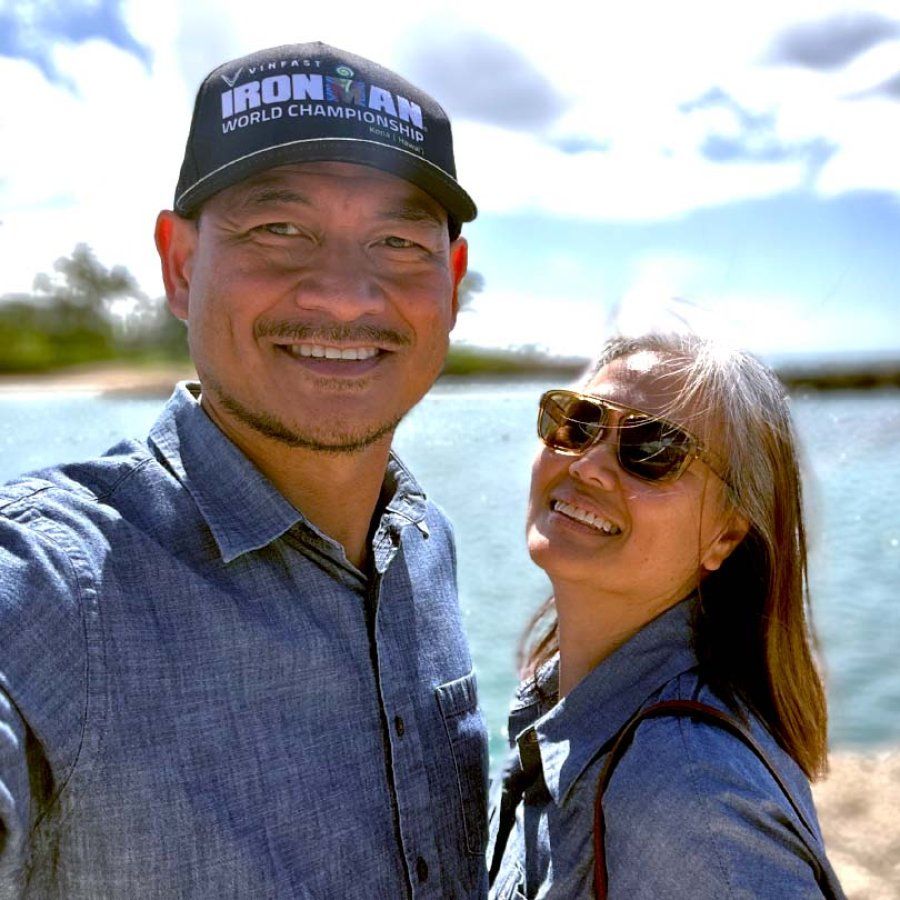 Jonathan Pascual and his wife take a selfie in front a body of water.