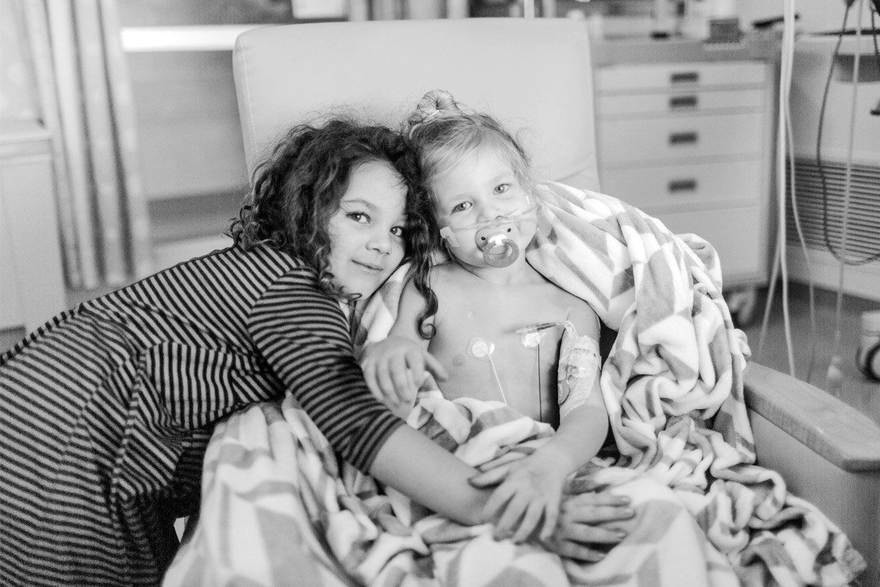 Big sister Presley gives Riley a hug in her hospital room.