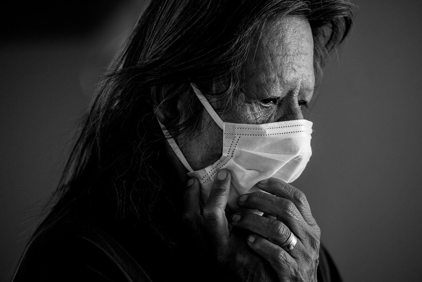 woman holds a mask on her face