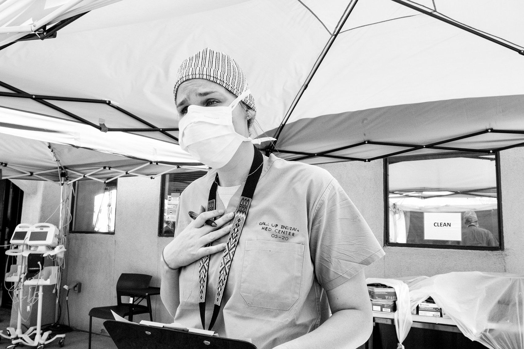 a medical worker talks while in an outdoor tent
