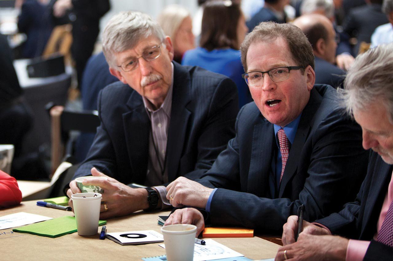 Two men sit discussing at a table.