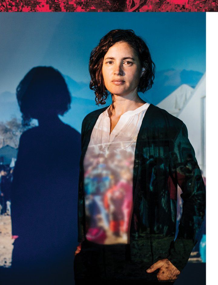 Portrait of Dr. Naomi Beyeler in a photo studio with a projection of hills and tents.