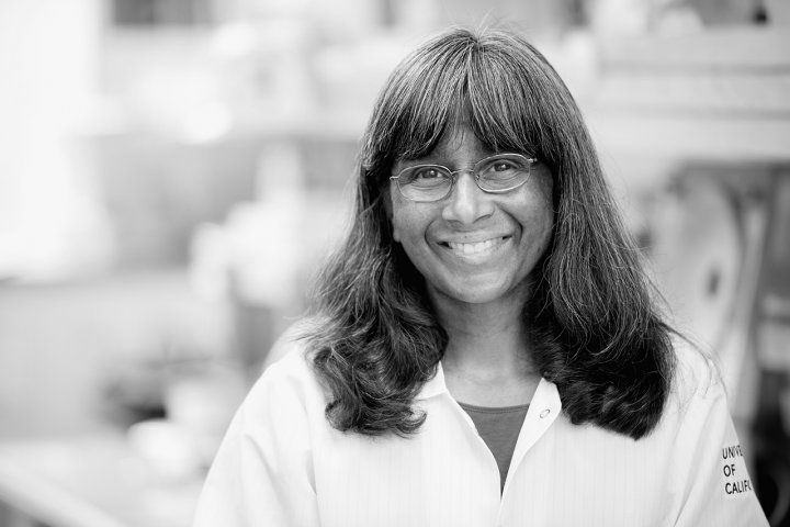 Portrait of Anita Sil with a laboratory in the background.