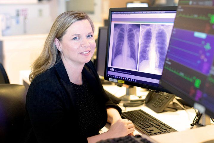 Photo of Rachel Callcut in front of computer screens.