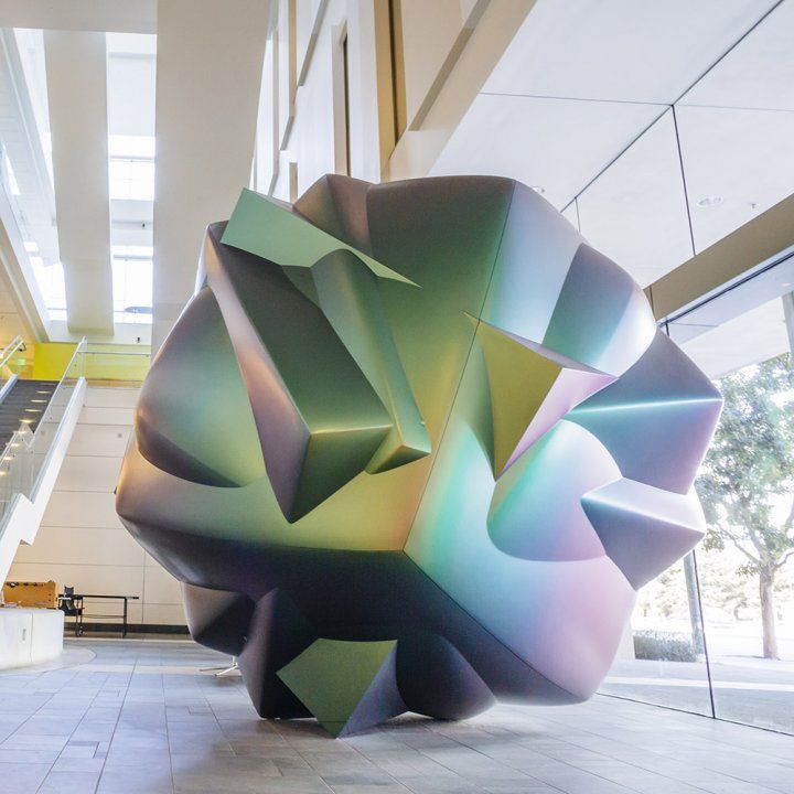 A multicolor multifaceted sculpture resembling a cell or microbe sits in the lobby