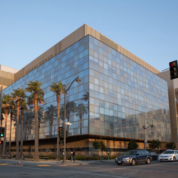 A line of palm trees sits before the sharply angled and highly reflective facade of the Smith Cardiovascular Research Building