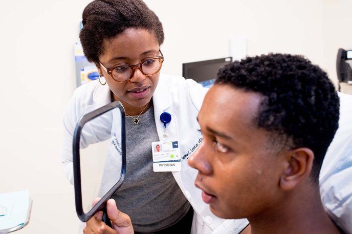 Dermatologist Jenna Lester looks over a male patient