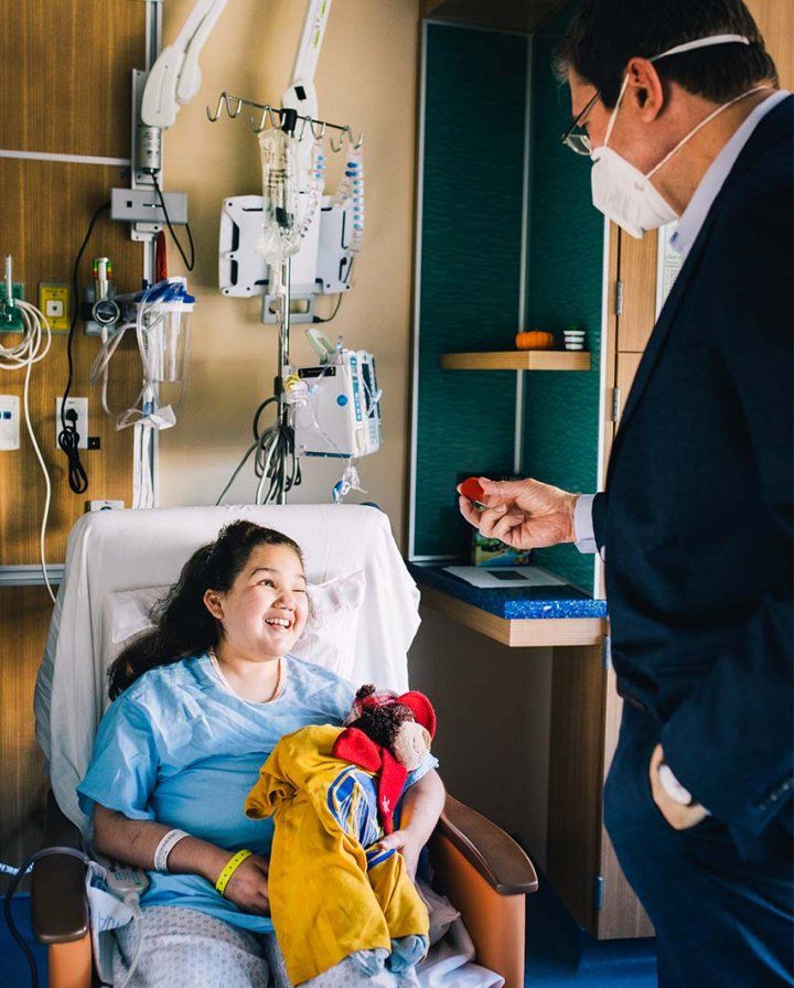 Stefan Friedrichsdorf performs a magic trick and puts the smile on the face of a young girl in a hospital room.