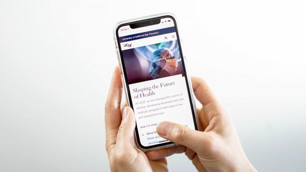 the UCSF.edu website homepage is shown on a mobile phone