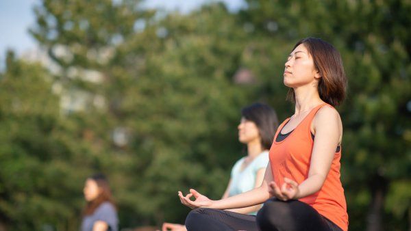 Three women meditating outisde