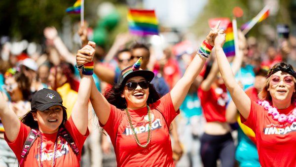 three people walk with their hands raised in the air