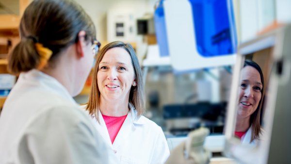 two researchers talk in a lab