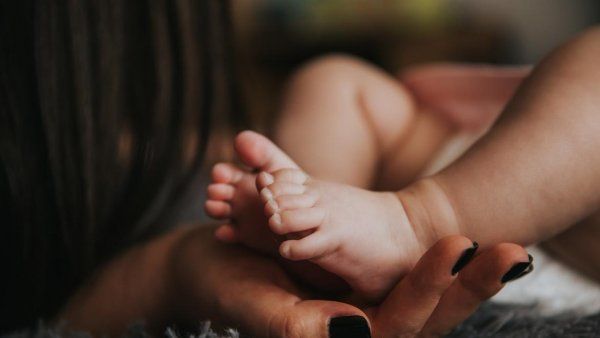 Mom's hand holding baby's feet