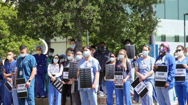 group holds signs during rally outside UCSF Mission Bay Medical Center