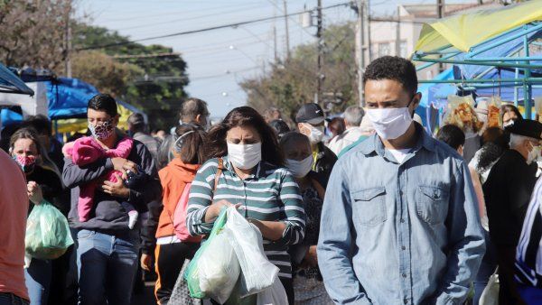 people walk with masks in a market in Brazil