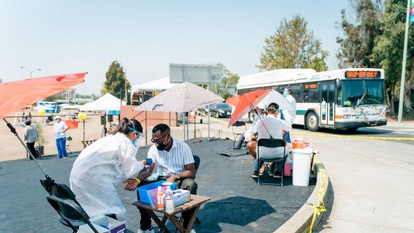 nurse administers a COVID test in a parking lot