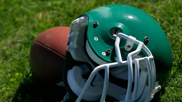 Green football helmet and football on grass