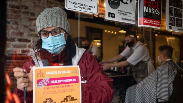 A volunteer tapes a COVID testing flyer to a window