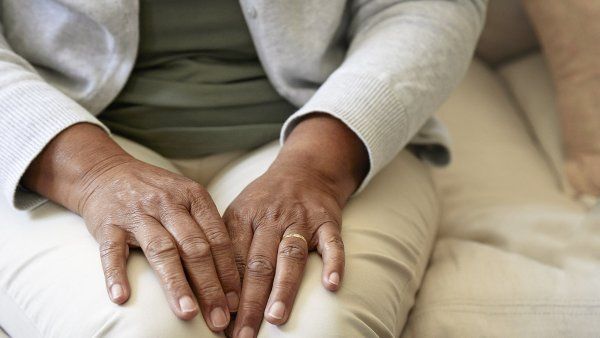 Black woman sitting with her hands on her lap