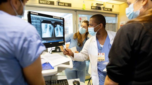 medical staff look at a respiratory image on a screen in the ICU 