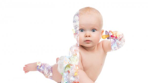 Photo of a Photo of a young baby in a diaper and  pushing itself up and holding a pacifier; transparent strips of plastic water bottles lay over the baby's skin.