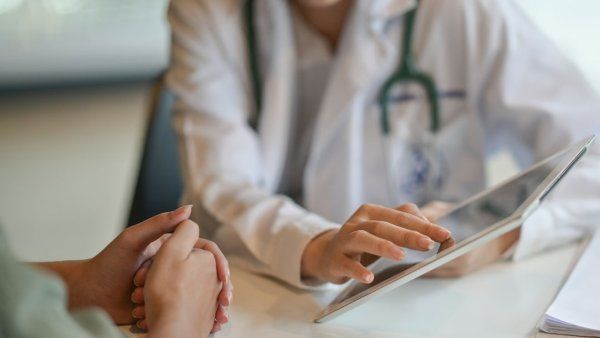 A Ddoctor showing a patient information on a digital tablet