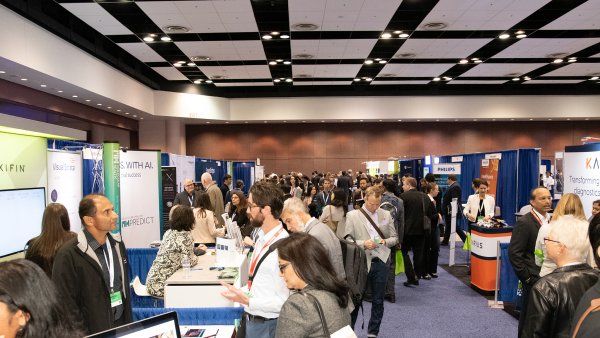Attendees visit booths at a conference center at the 2019 Precision Medicine World Conference