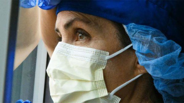 Photo of a hospital worker in PPE looking stressed