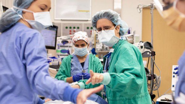A group of medical professionals in scrubs prepare for surgery