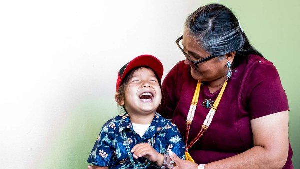 A young boy laughs with his grandmother.